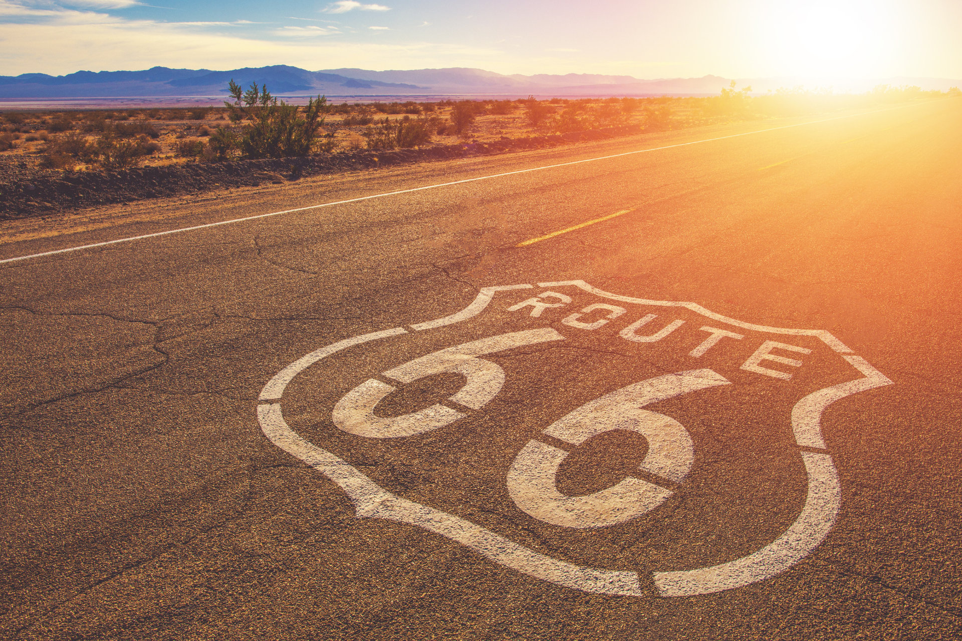 A route 66 sign is painted on the side of a road.
