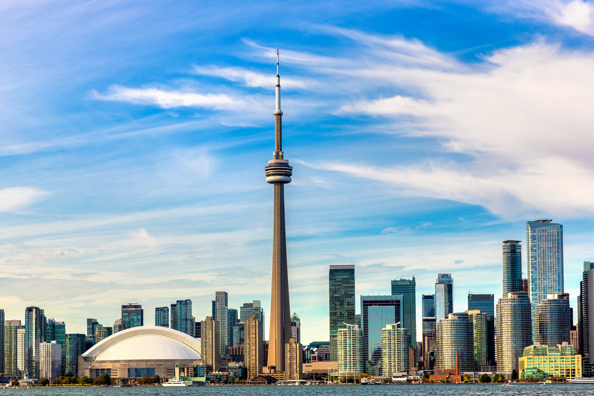 A city skyline with a very tall tower in the middle of it.