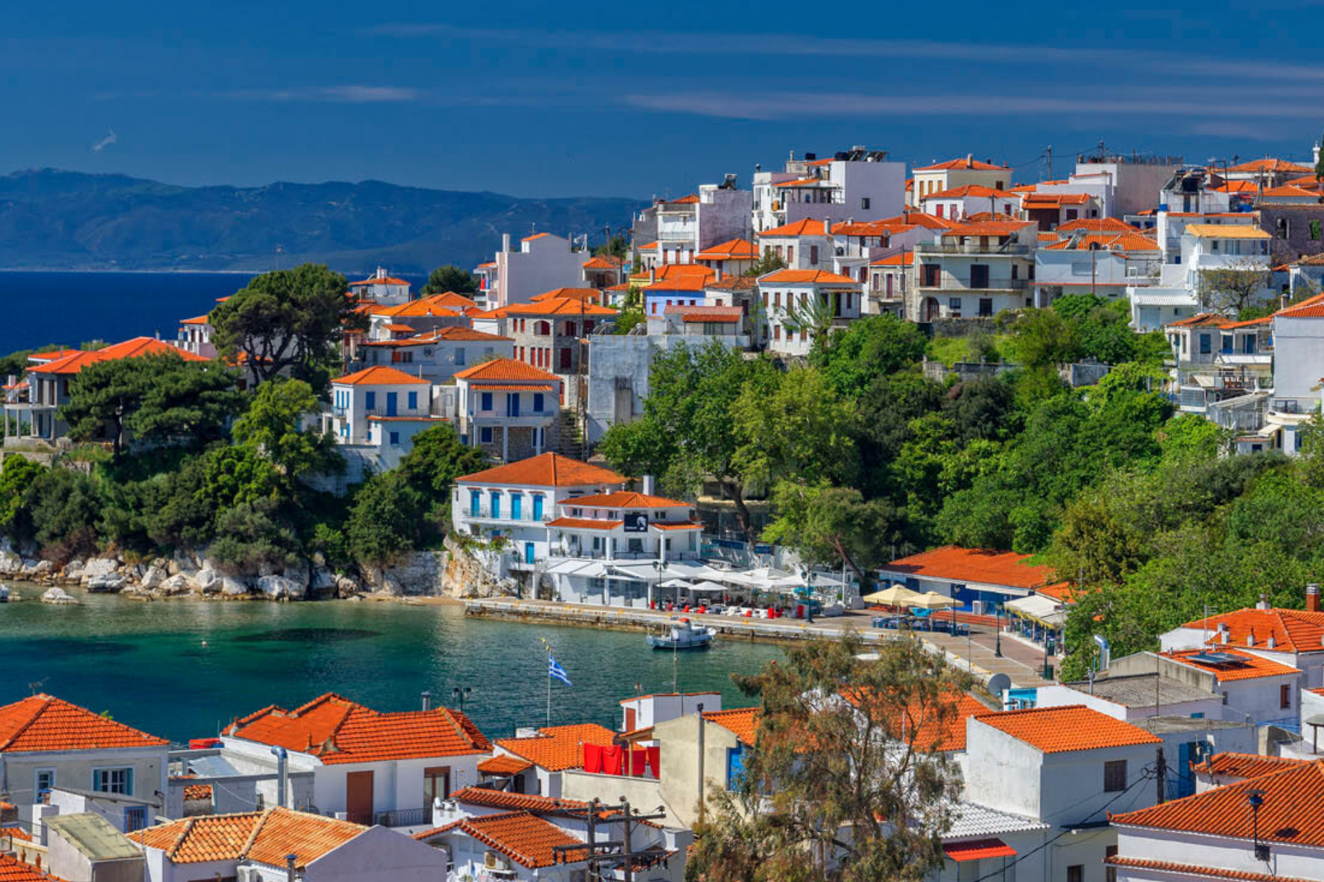 An aerial view of a small town on a hill overlooking a body of water.