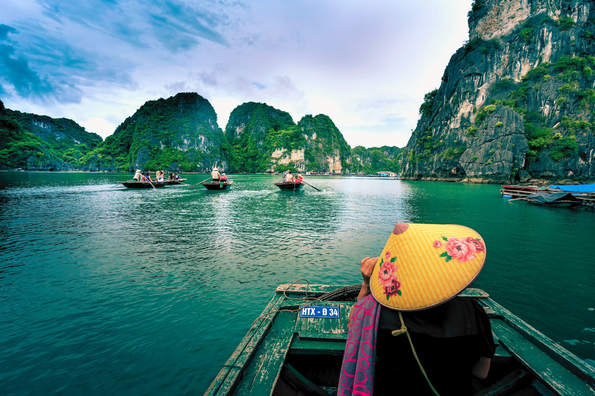 A woman in a yellow hat is sitting in a boat on a lake