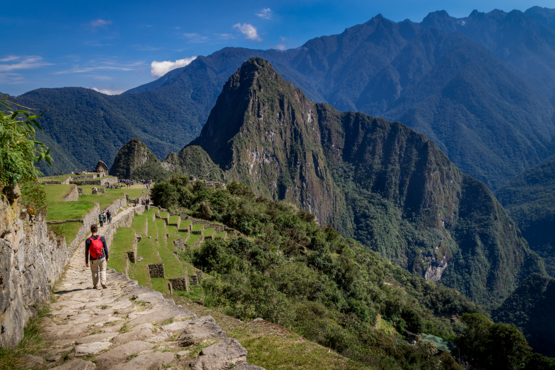 A man is walking down a path in the mountains.