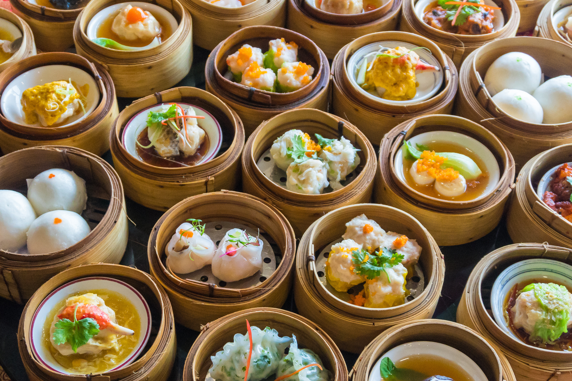 A variety of dim sum in bamboo baskets on a table.