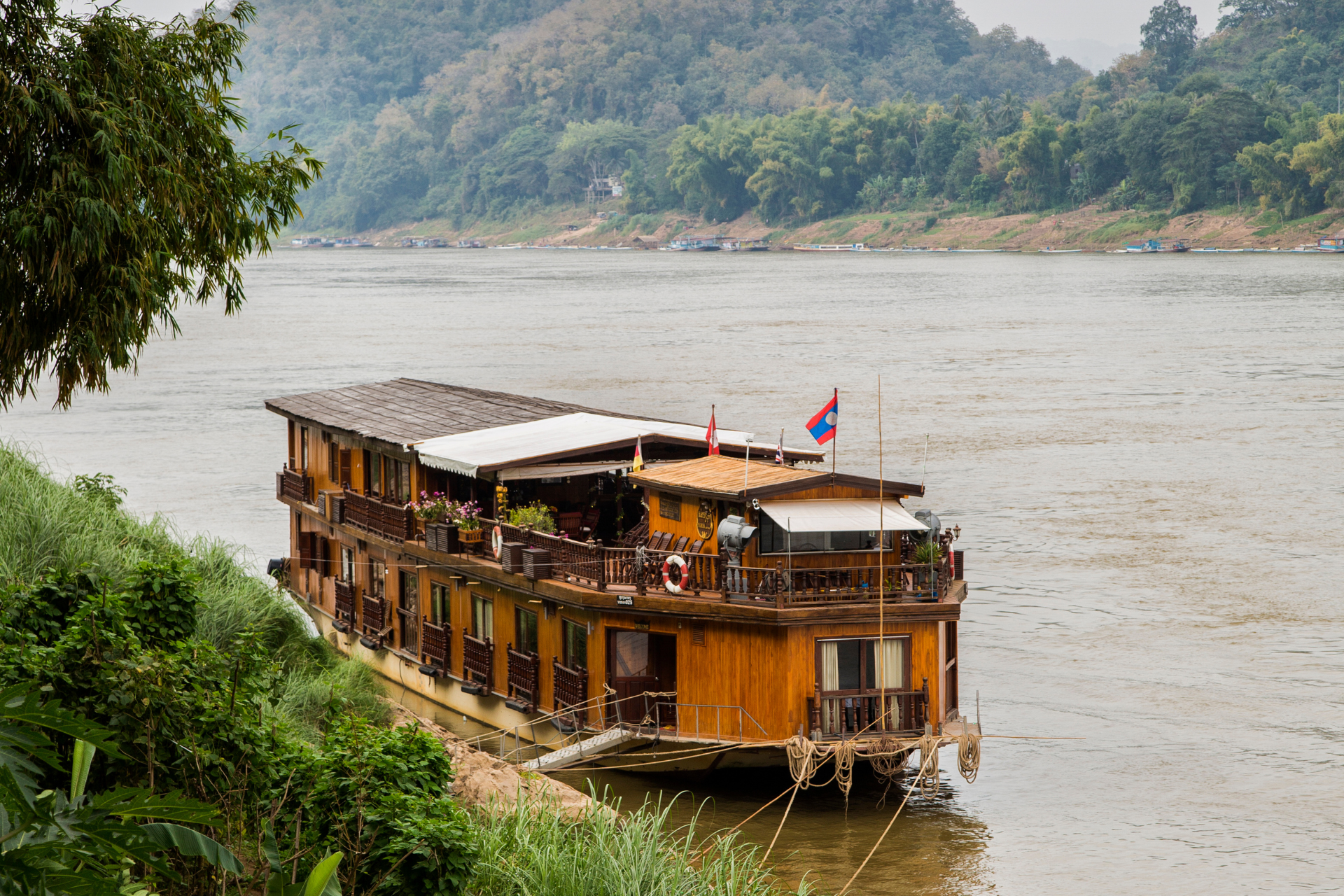 A boat is docked on the shore of a river.