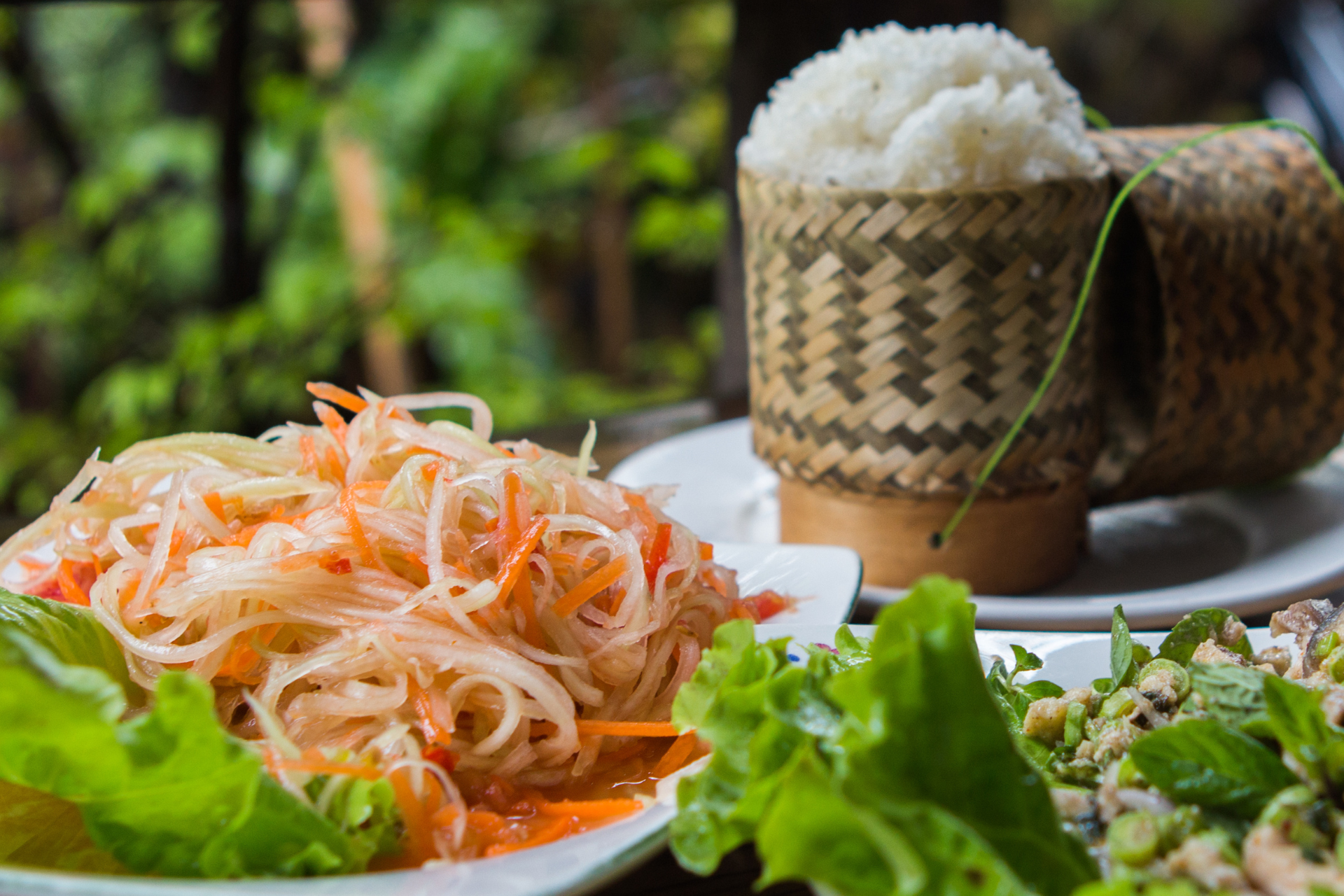 A table topped with plates of food and rice.