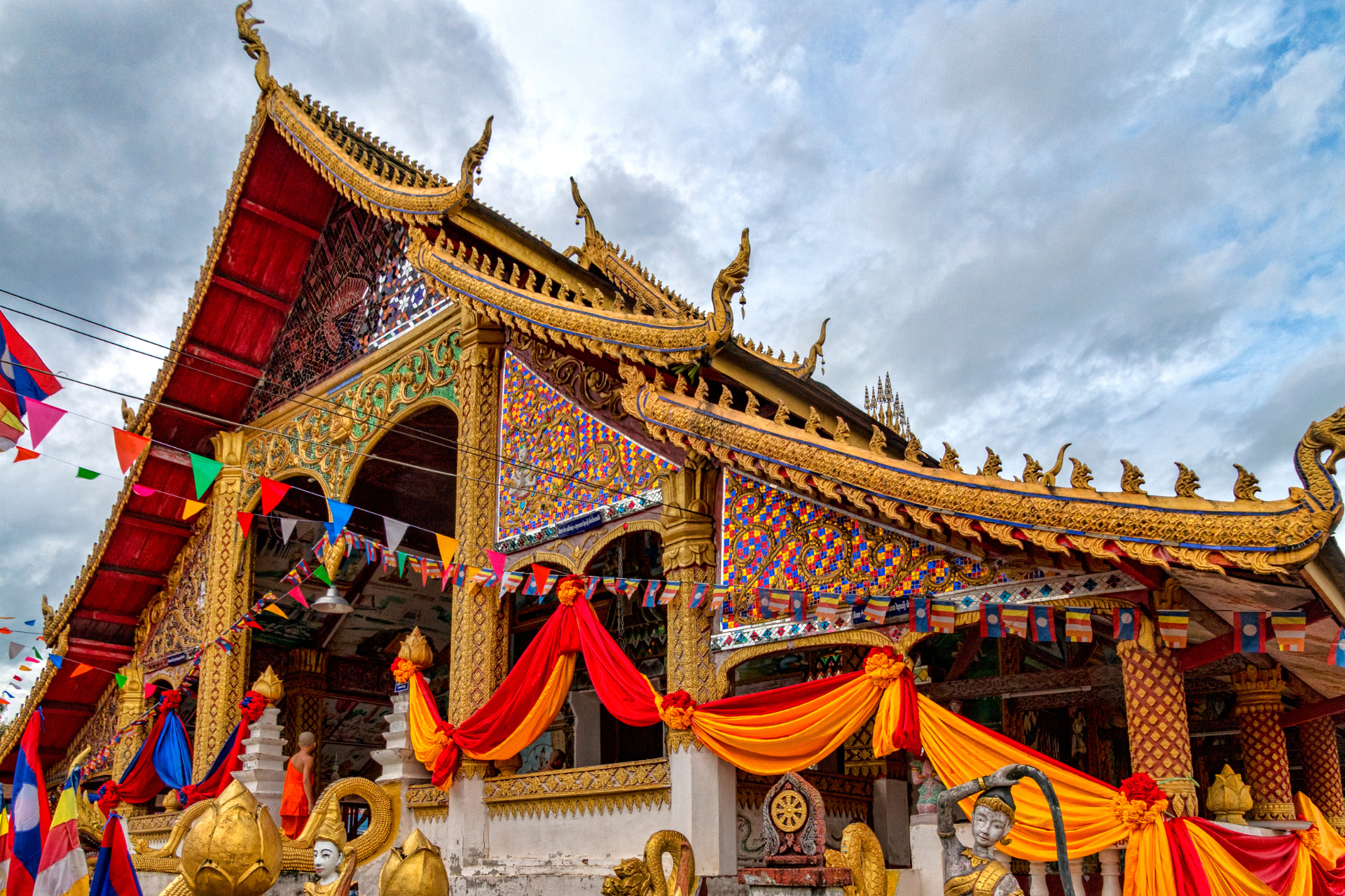 A very colorful temple with flags and flags hanging from the roof.