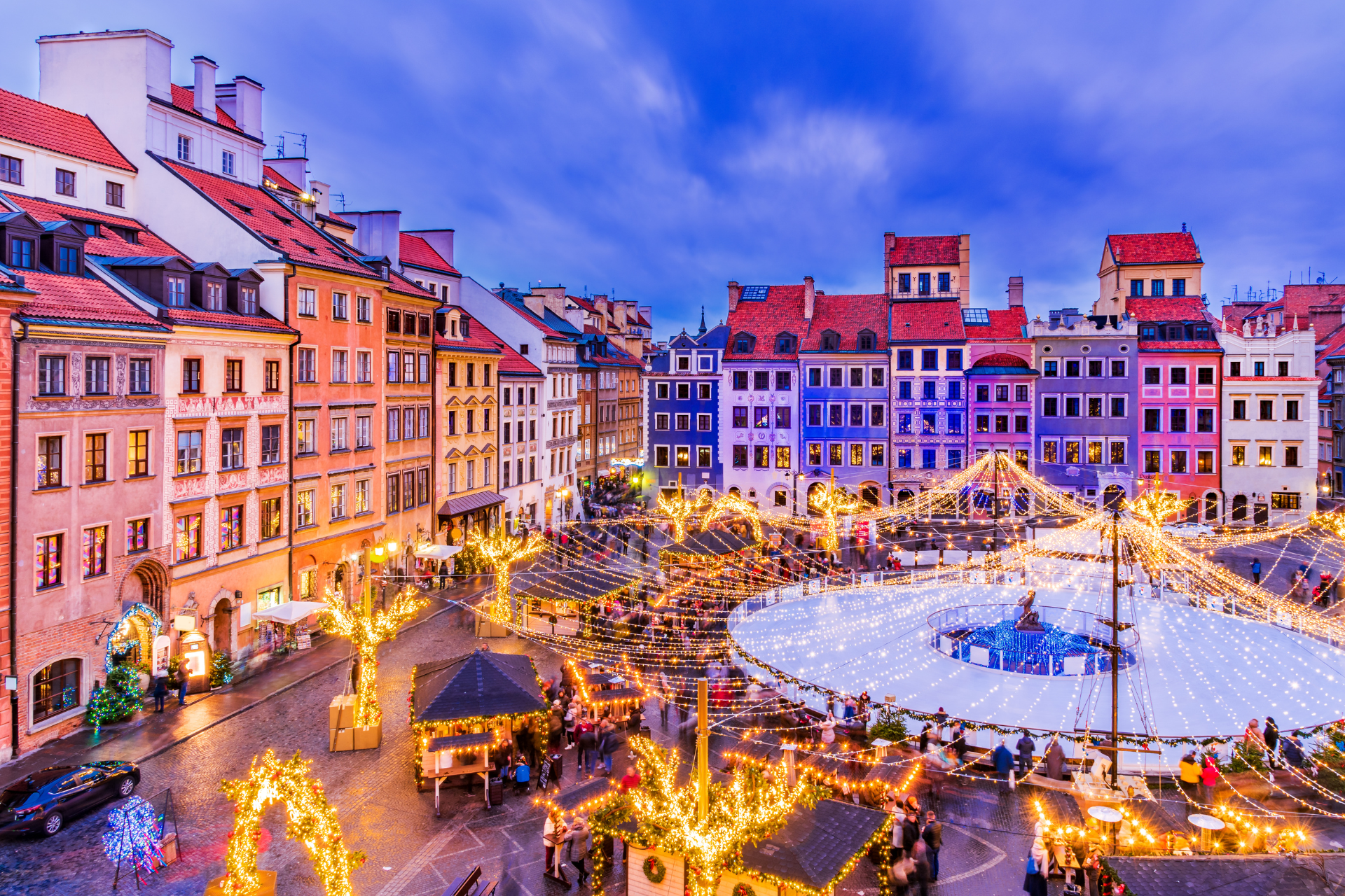 An aerial view of a christmas market in a city at night.