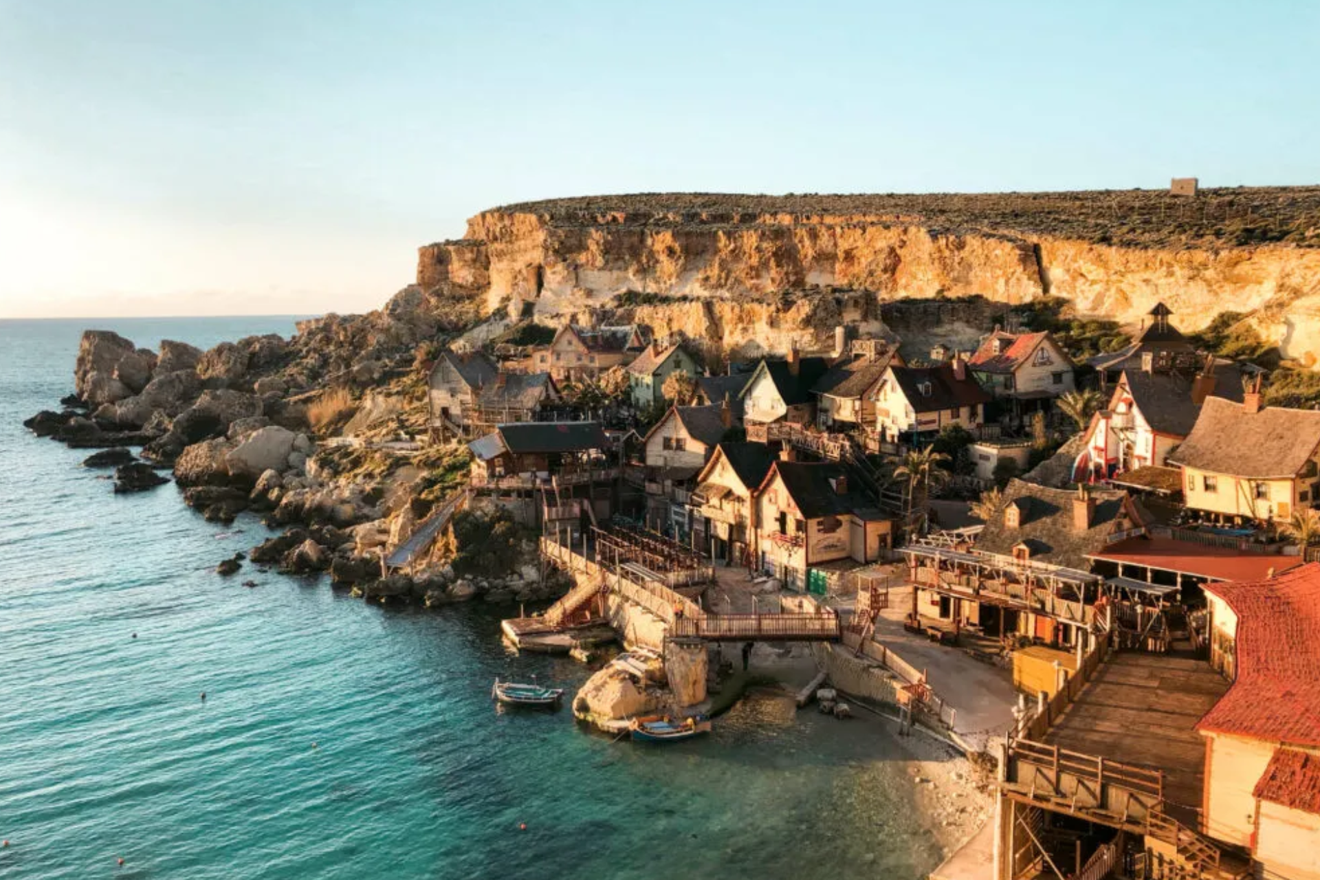 An aerial view of a small town on a cliff overlooking the ocean.