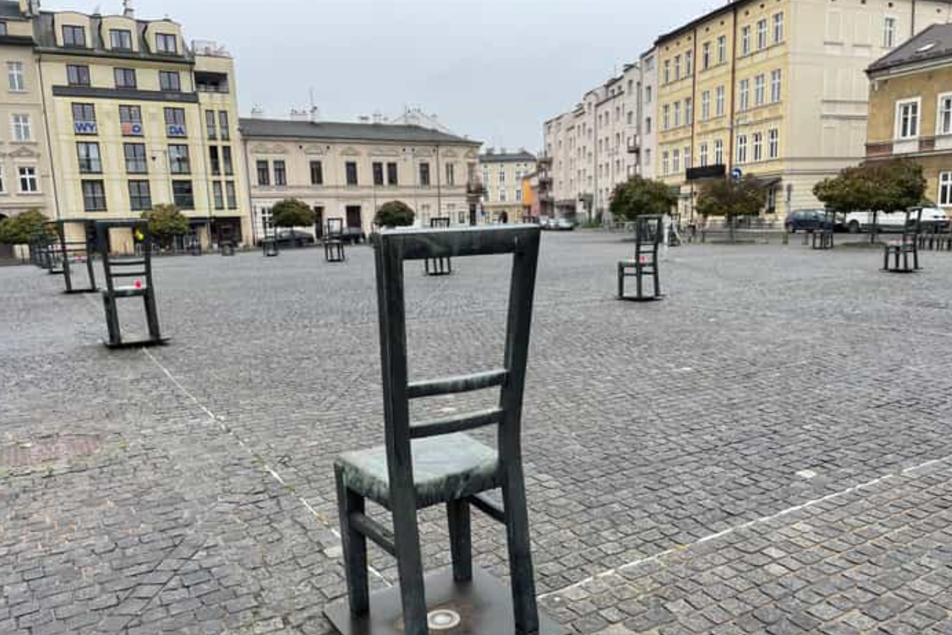 A group of chairs are sitting in a square in front of a building.