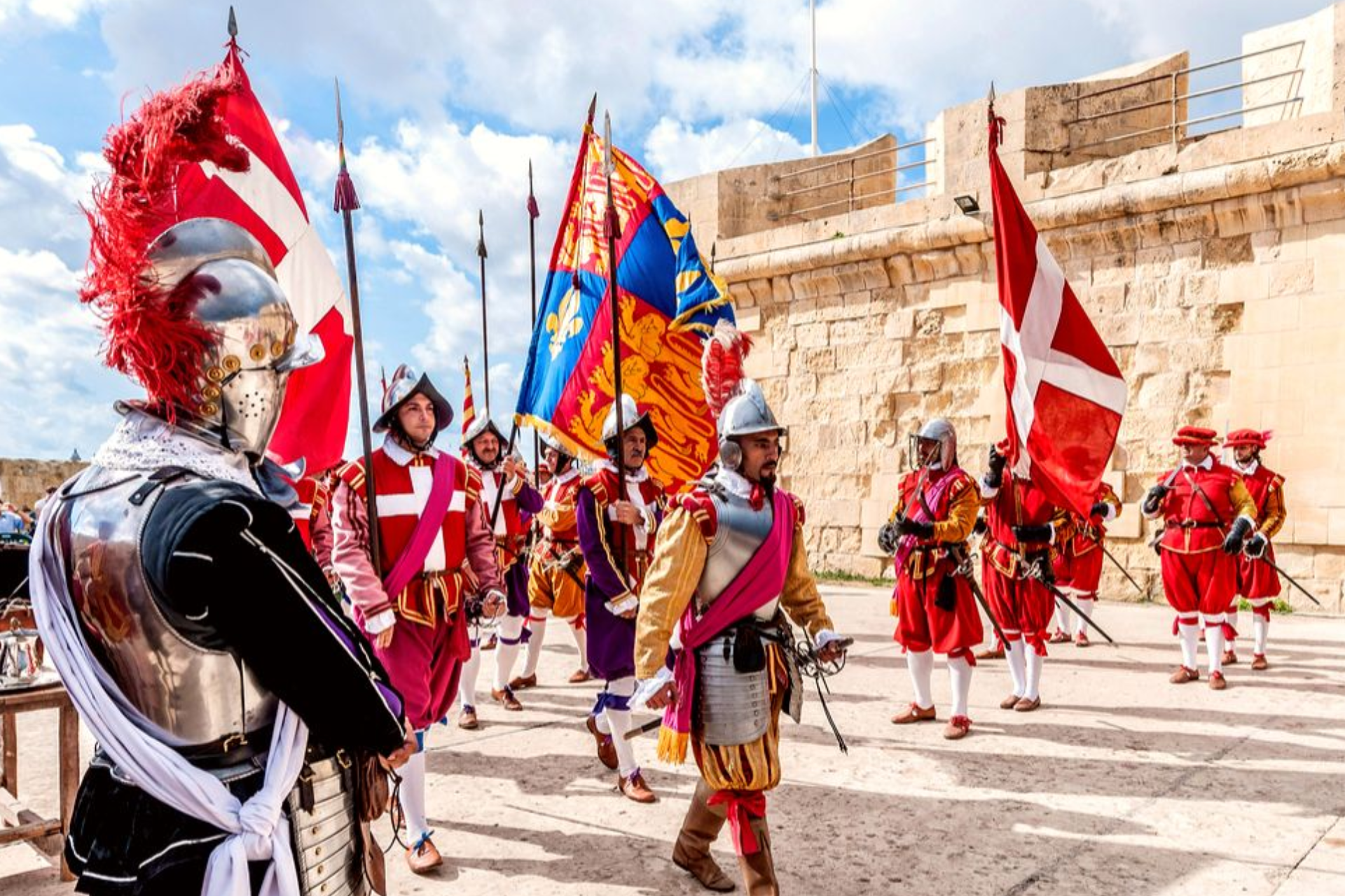 A group of men in medieval costumes holding flags and swords.