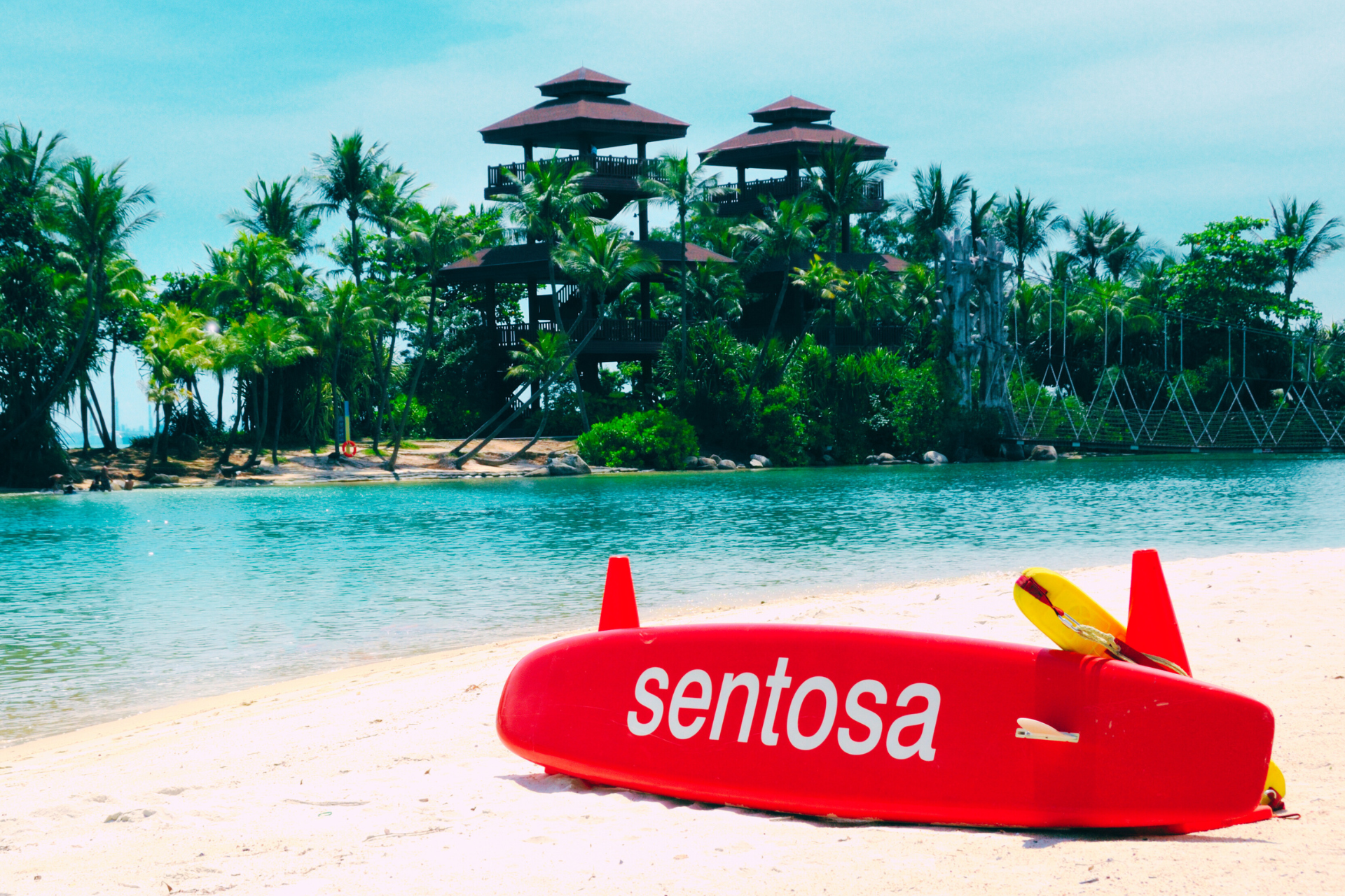 A red surfboard with the word sentosa on it