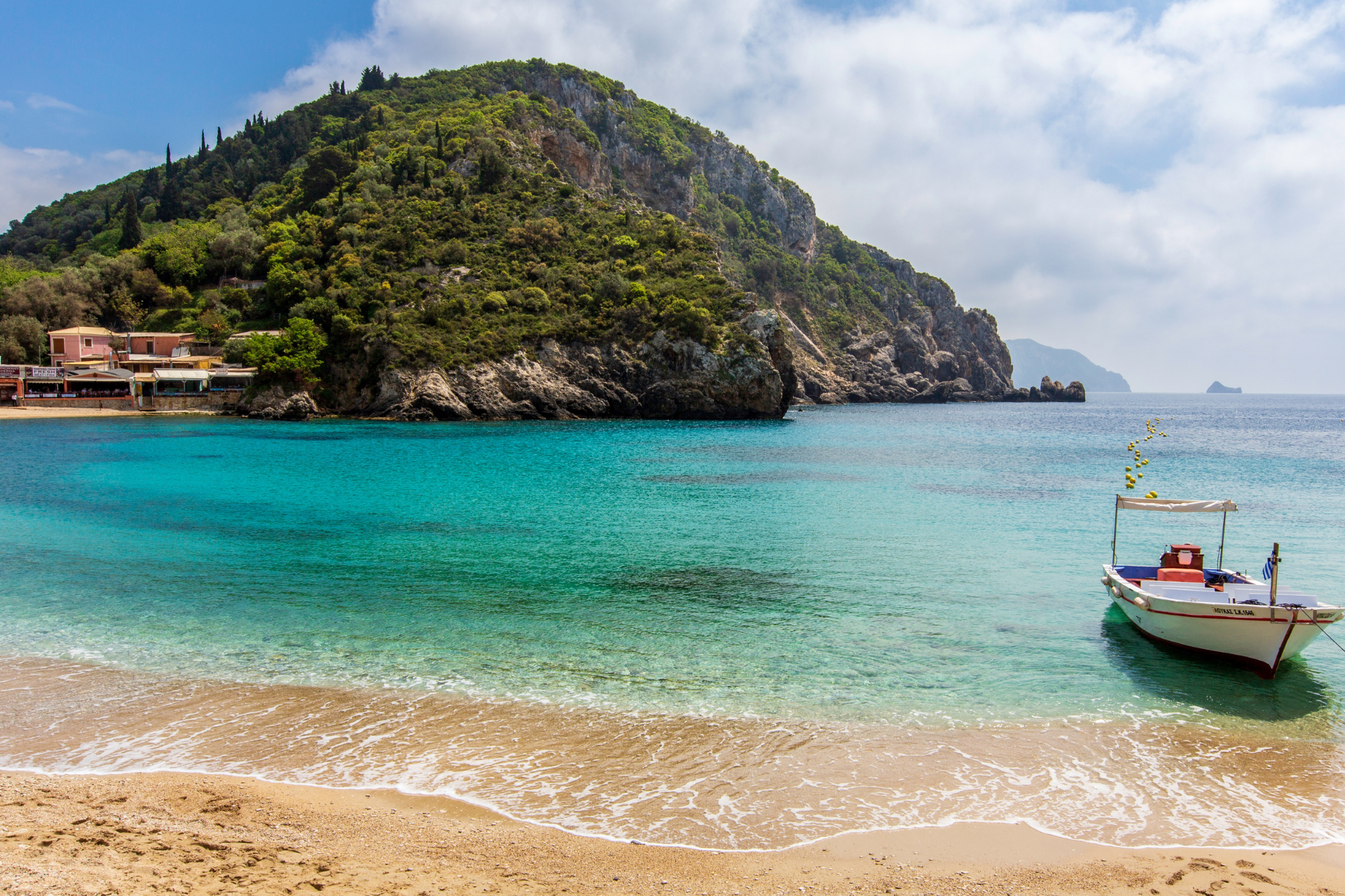 A small boat is sitting on the shore of a beach.