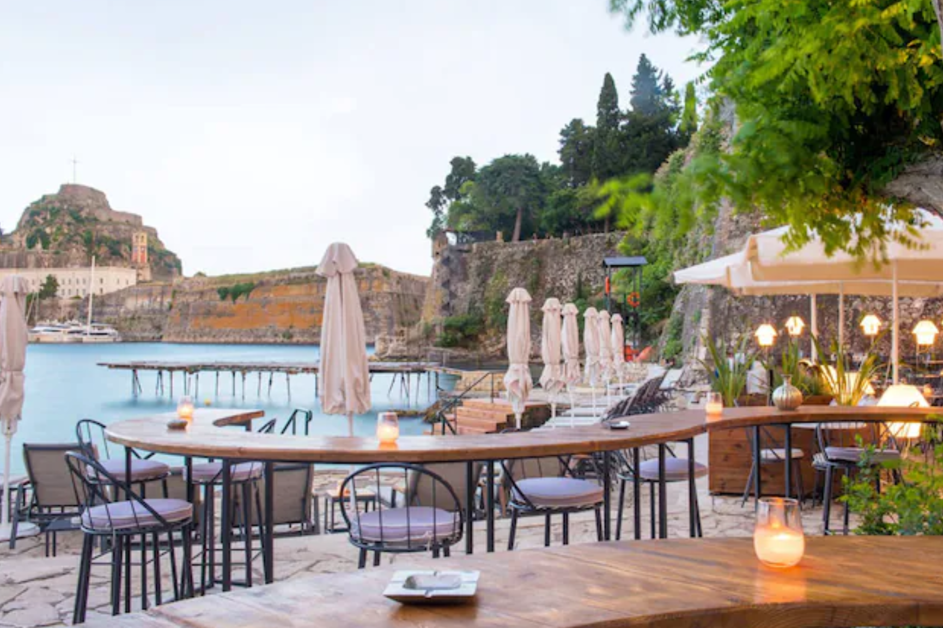 A restaurant with tables and chairs next to a body of water.