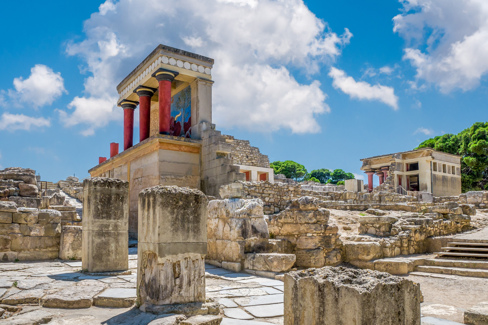 A group of ancient ruins with columns and a building in the background.