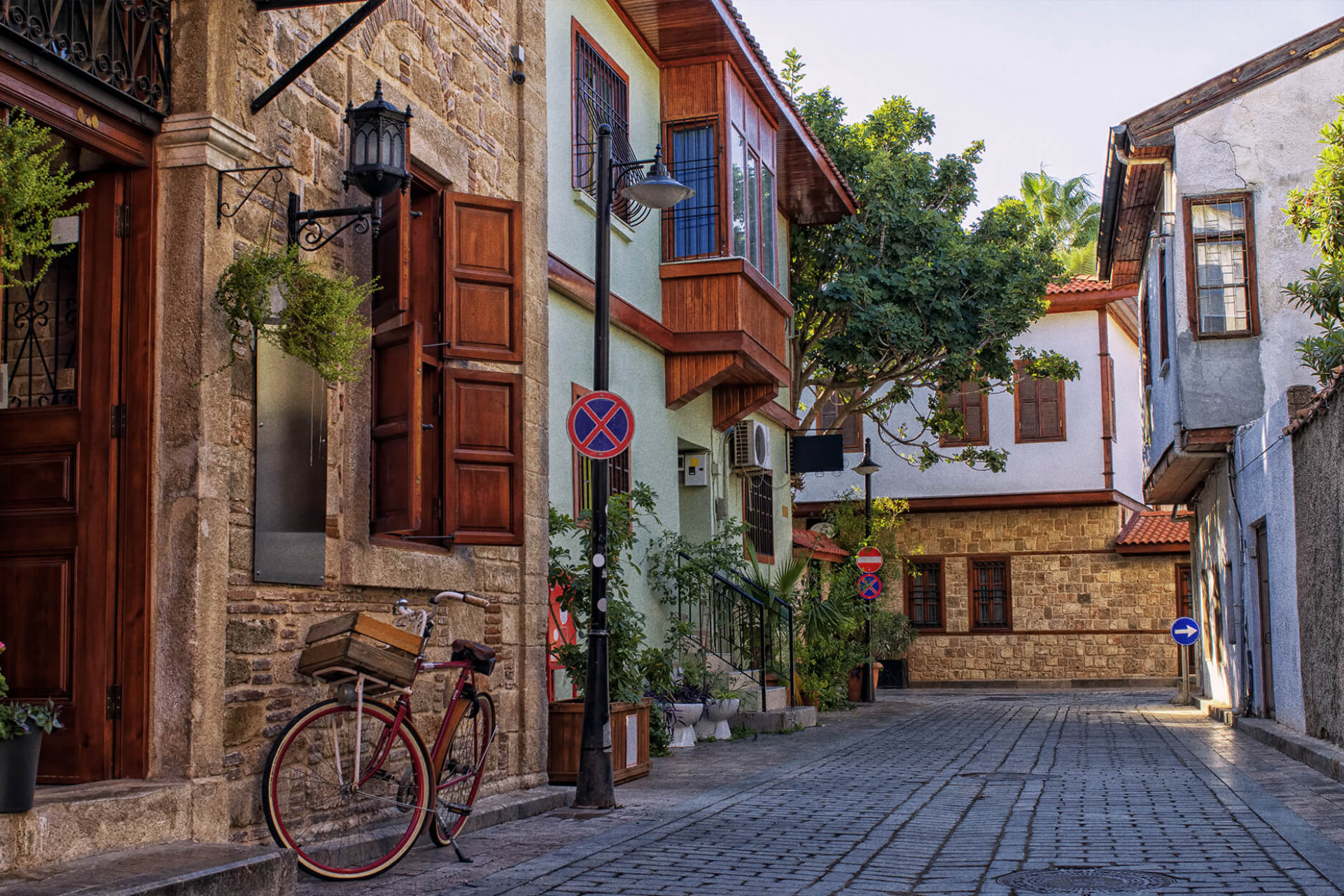 A bicycle is parked on the side of a cobblestone street.