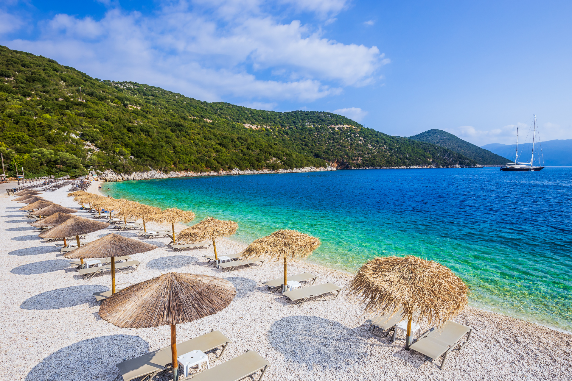 There are many umbrellas and chairs on the beach.