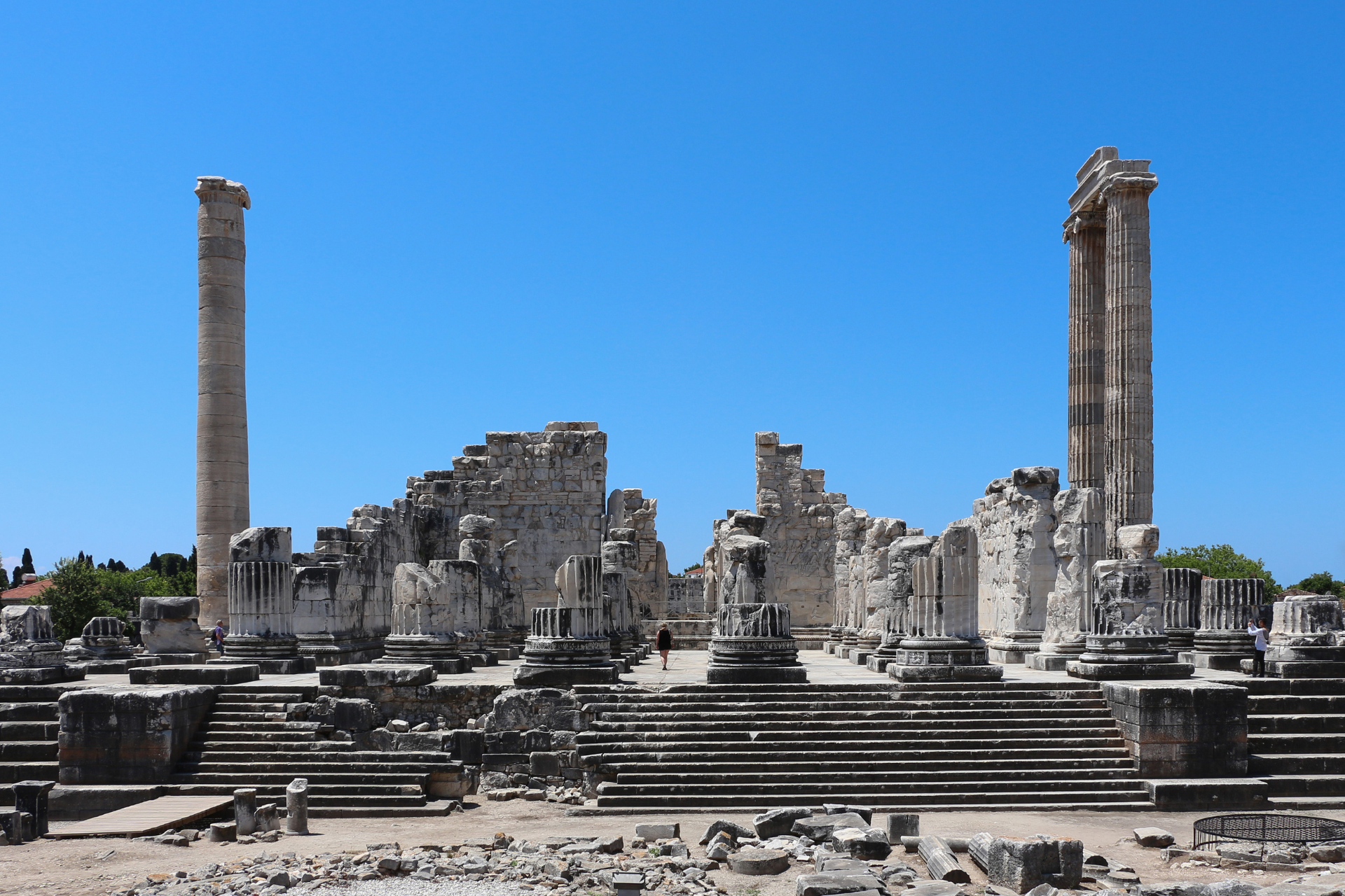 A ruined temple with columns and stairs in front of a blue sky.