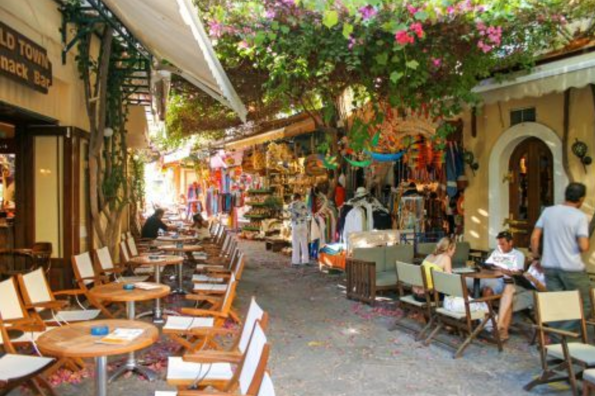 A street with tables and chairs and a sign that says old town