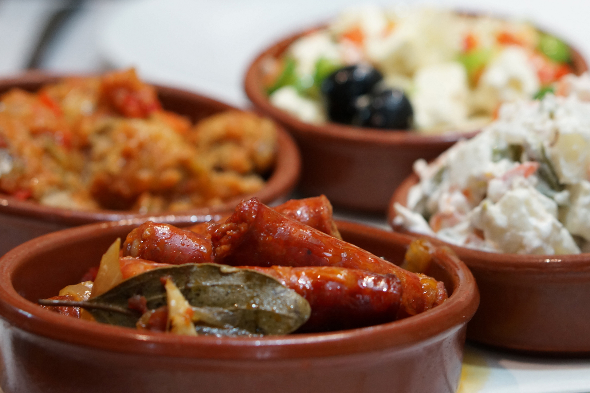 A row of bowls filled with different types of food on a table.