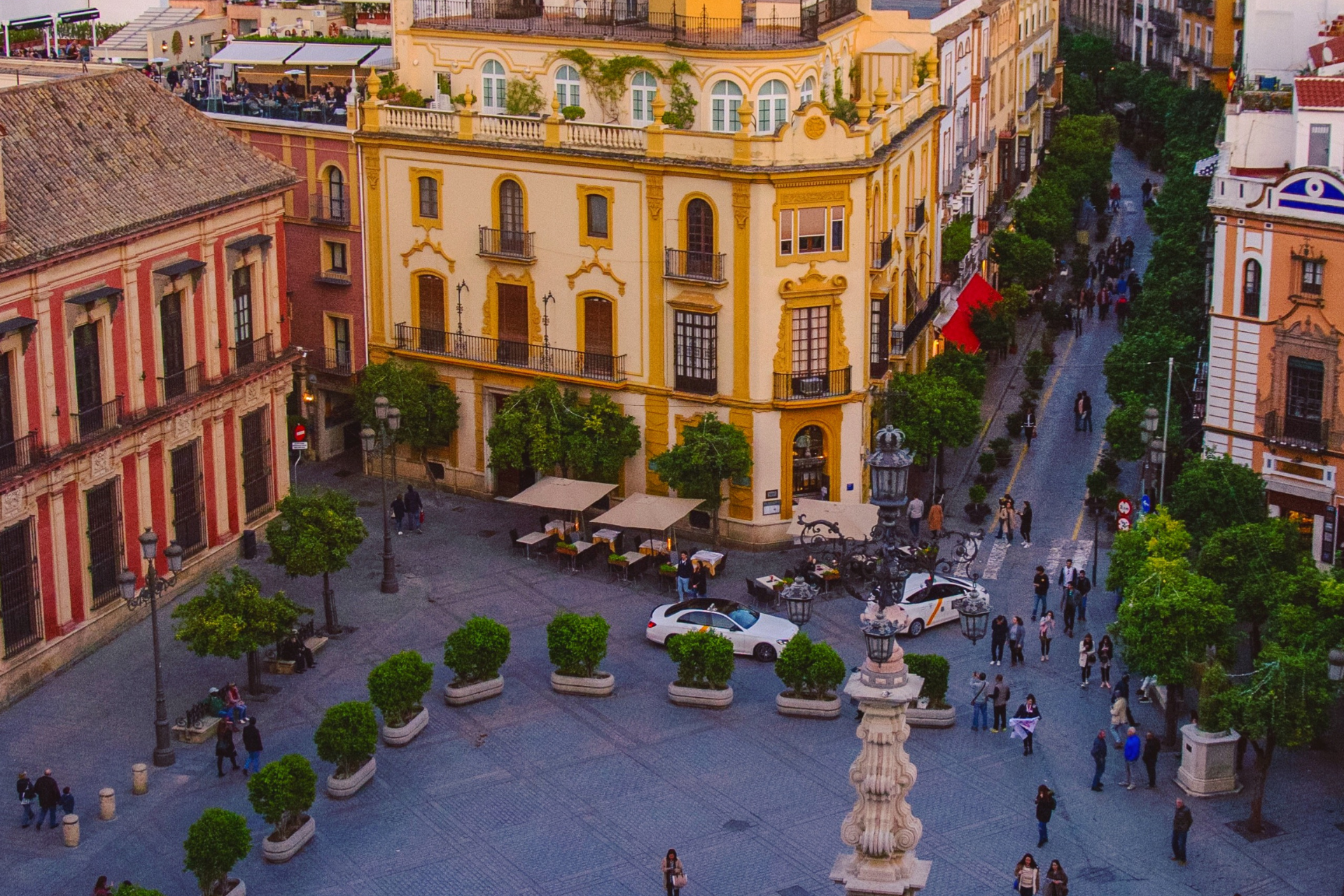 An aerial view of a city square with a fountain in the middle.