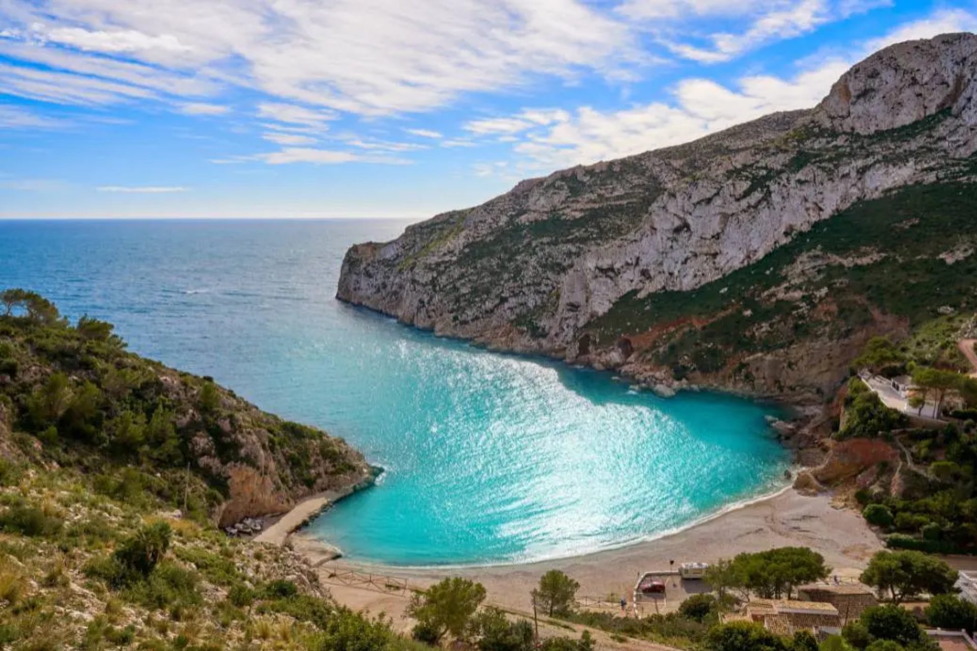 A large body of water surrounded by mountains and trees.