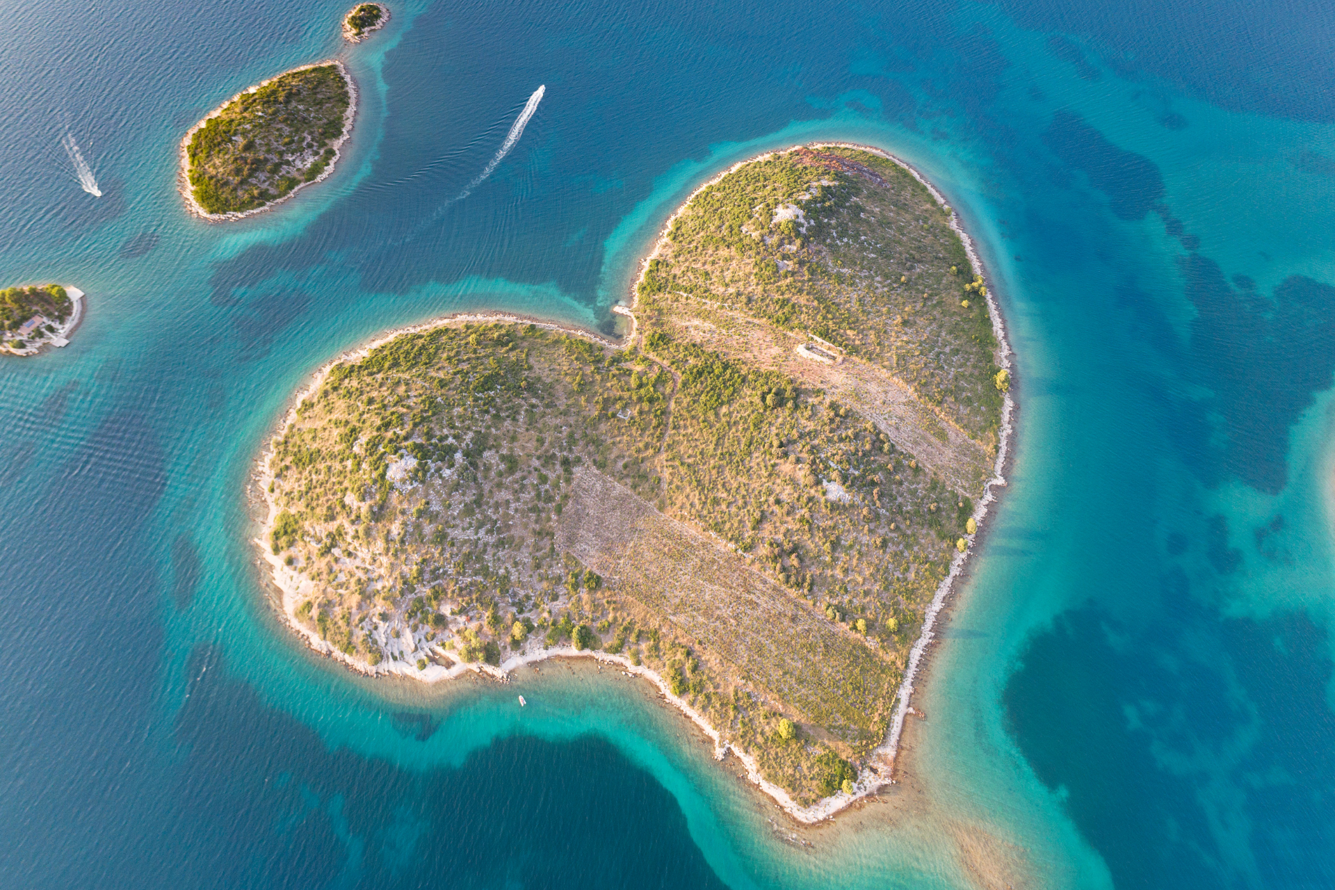 An aerial view of a heart shaped island in the middle of the ocean.