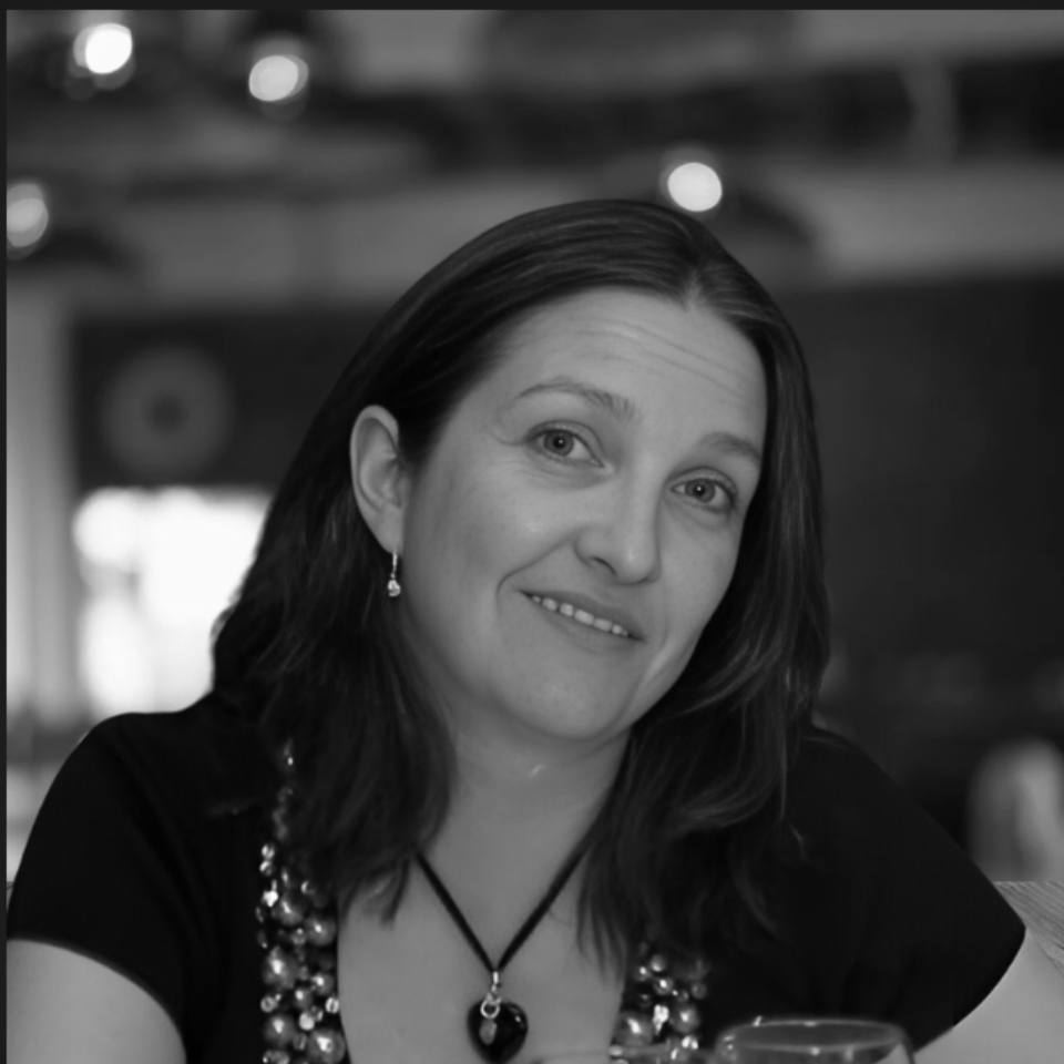 A black and white photo of a woman wearing a necklace and earrings