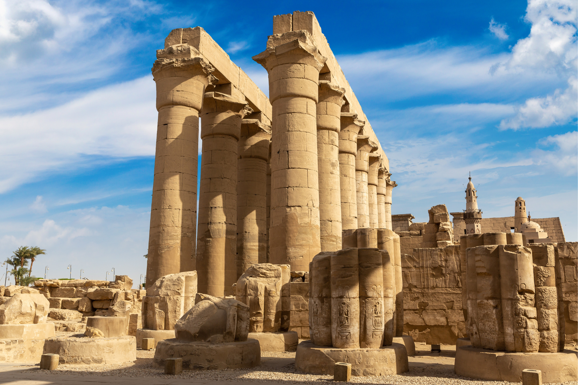 A row of columns in a temple with a blue sky in the background.