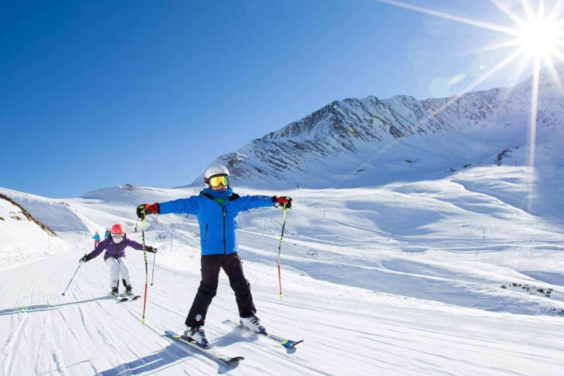 A man and a child are skiing down a snow covered slope.