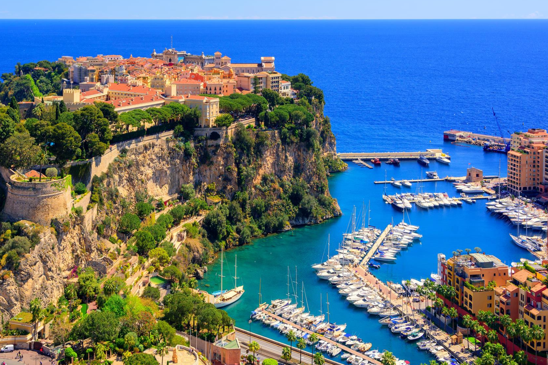 An aerial view of a harbor with boats docked in it and a city in the background.