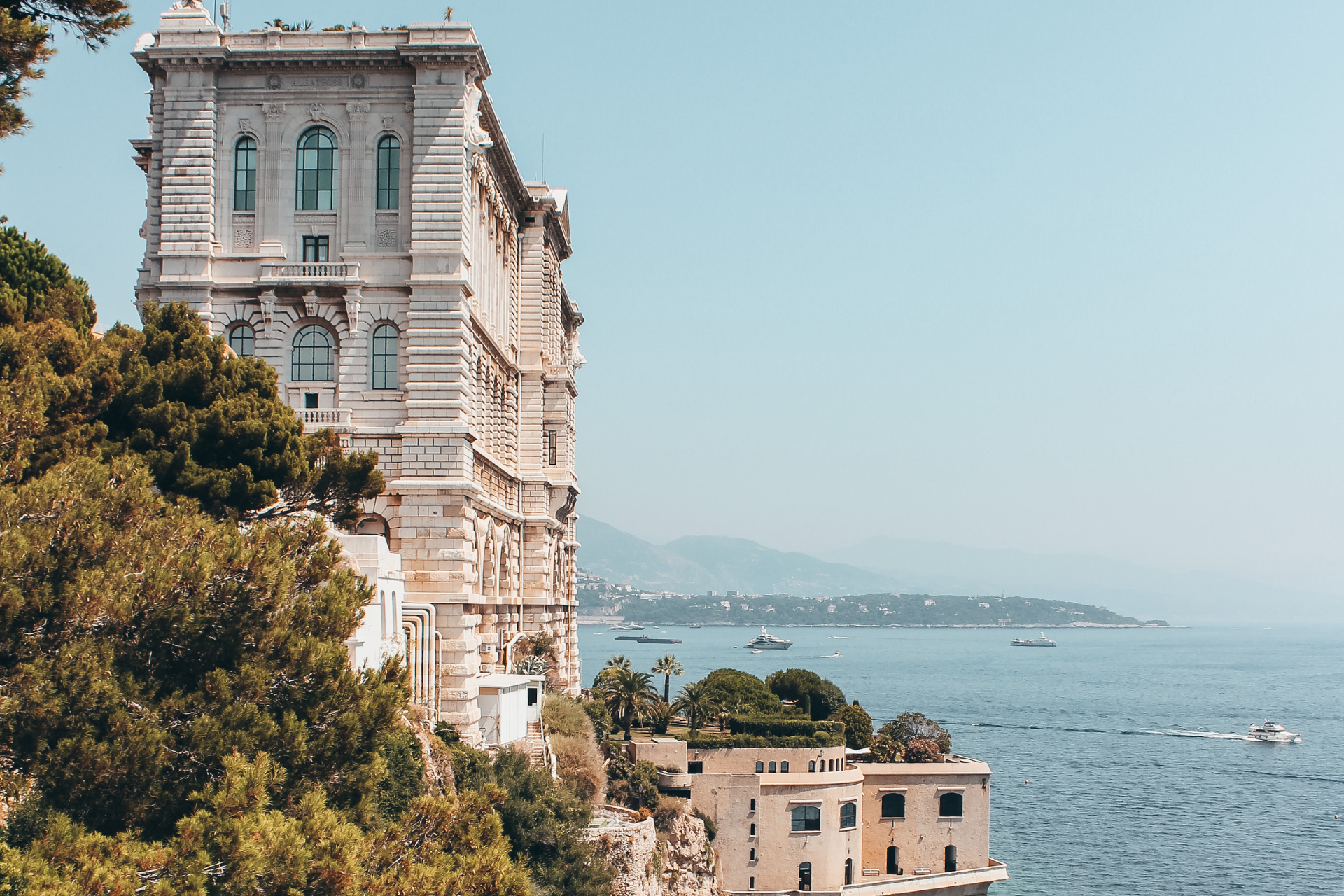 A large building is sitting on top of a cliff overlooking the ocean.