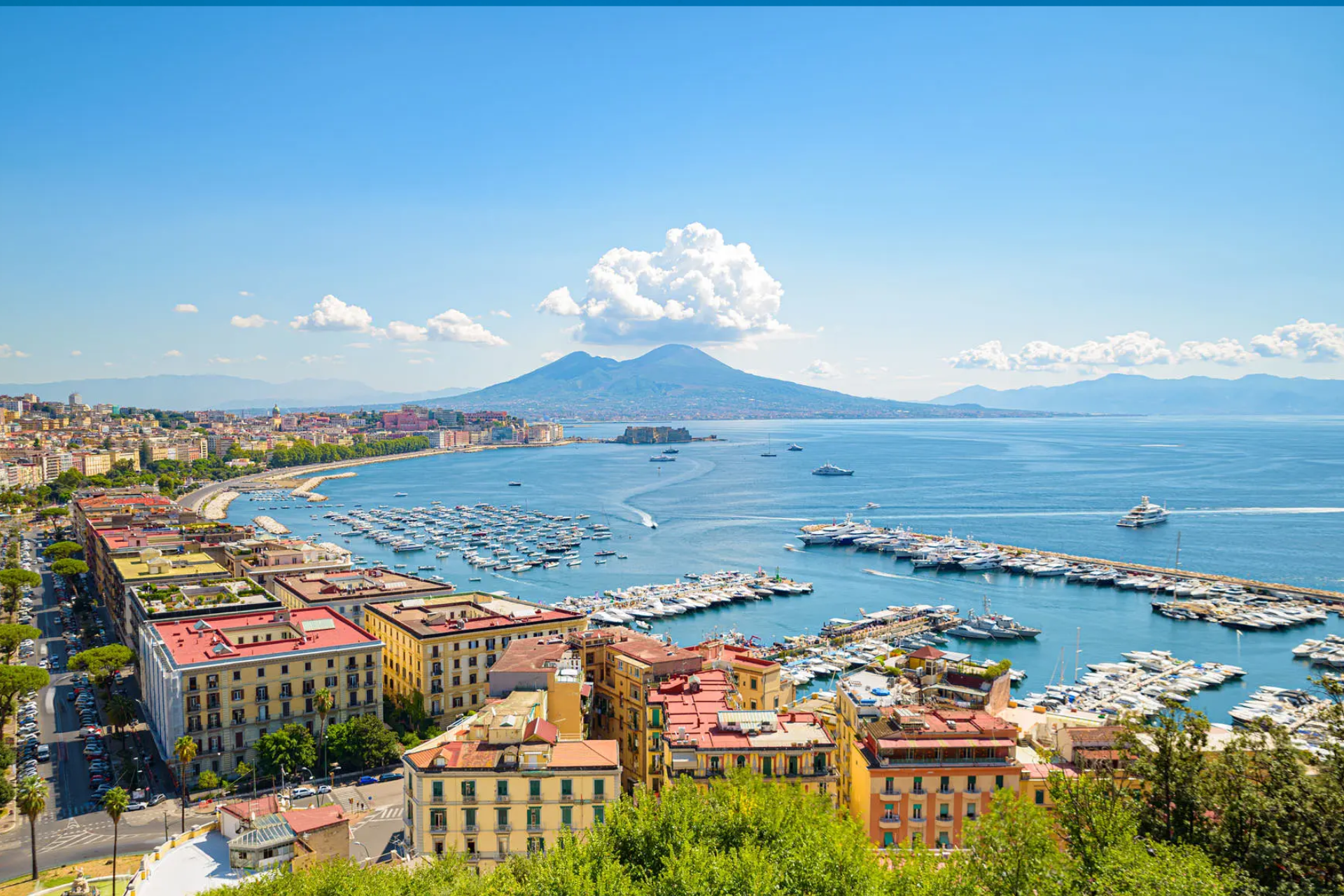 An aerial view of a city and a harbor with a mountain in the background.