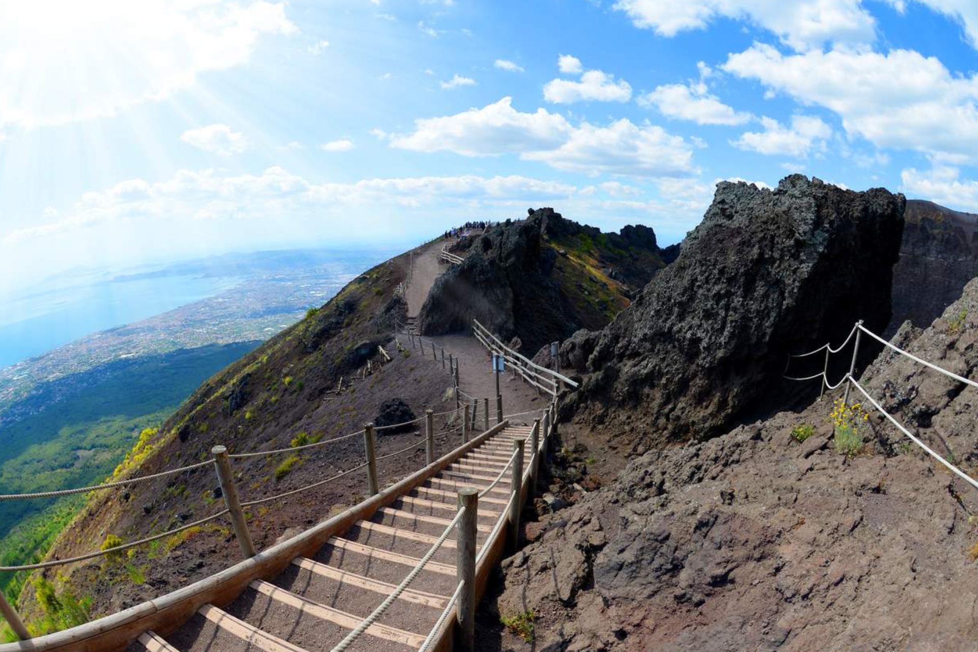 A wooden staircase leading up to the top of a mountain.