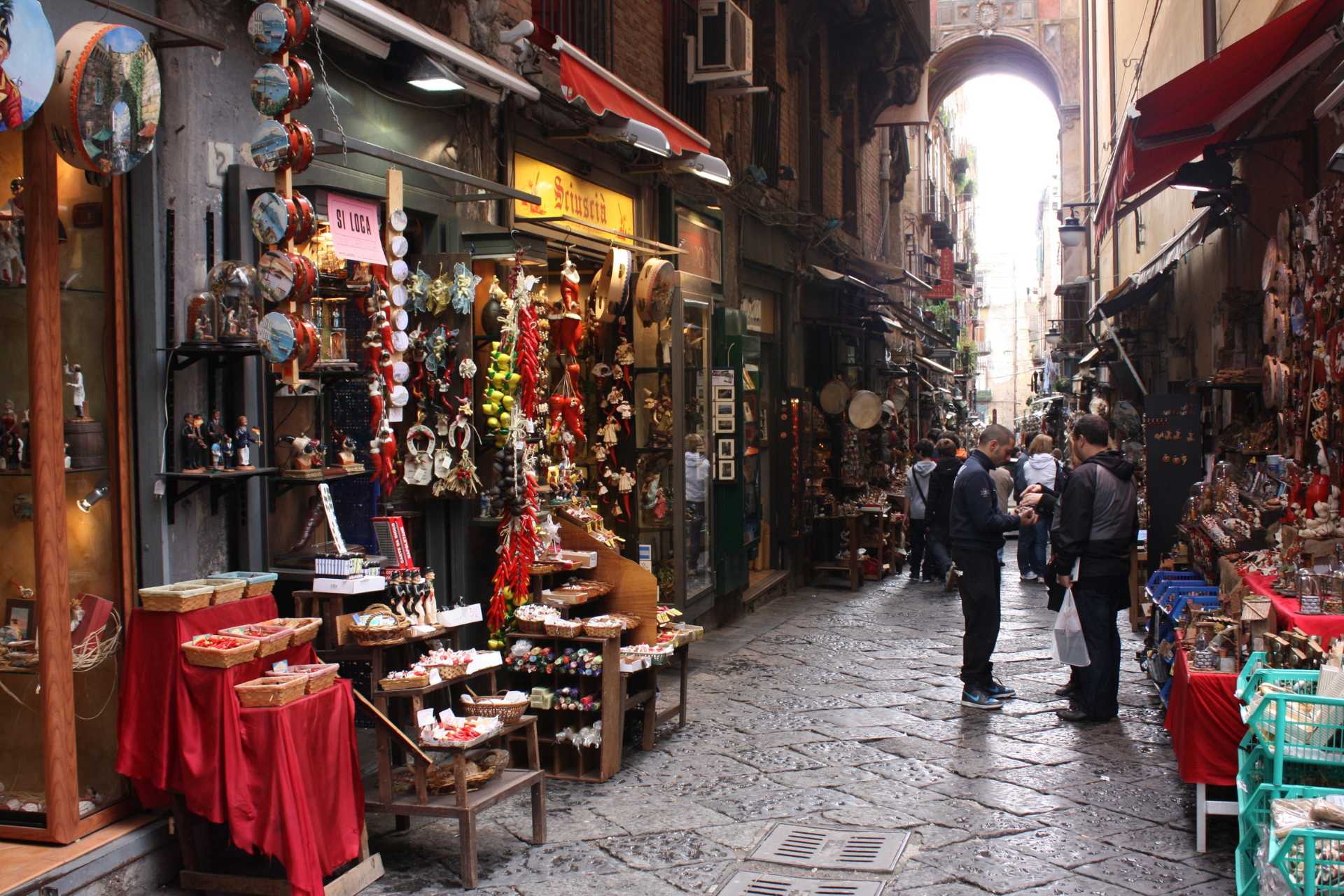 A narrow alleyway filled with lots of shops and people