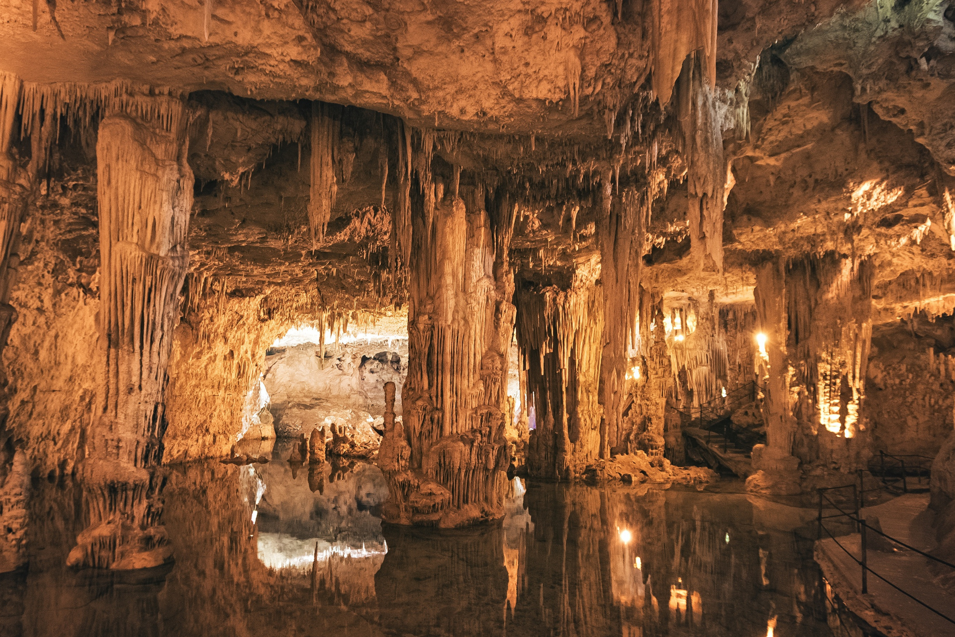 A cave with water and icicles hanging from the ceiling