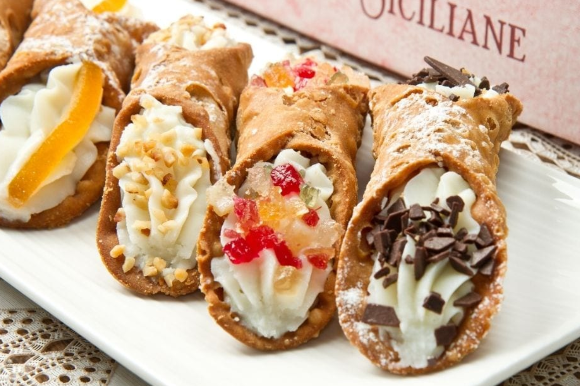 A white plate topped with cannoli with different toppings