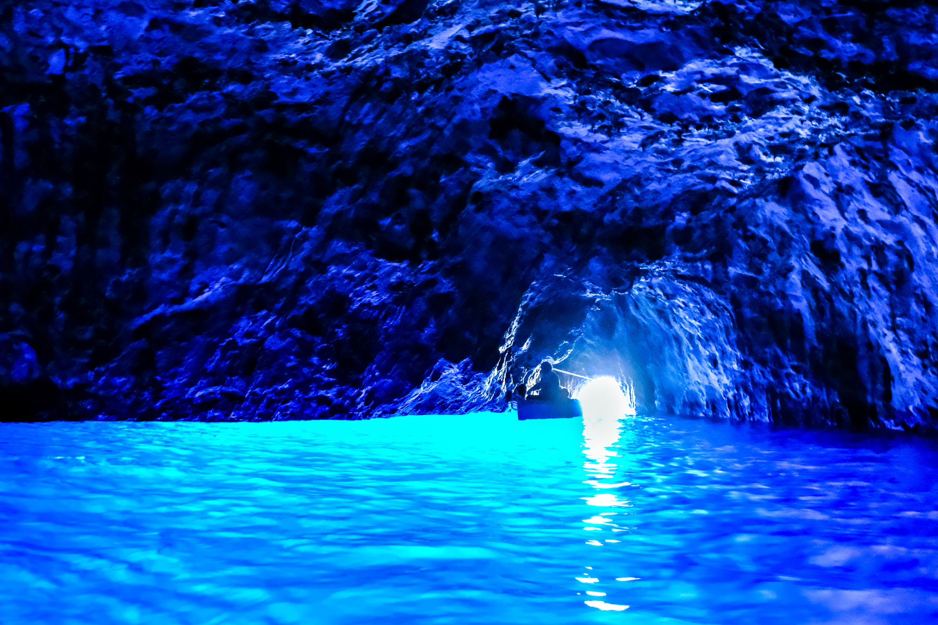 A blue cave with a light coming out of it