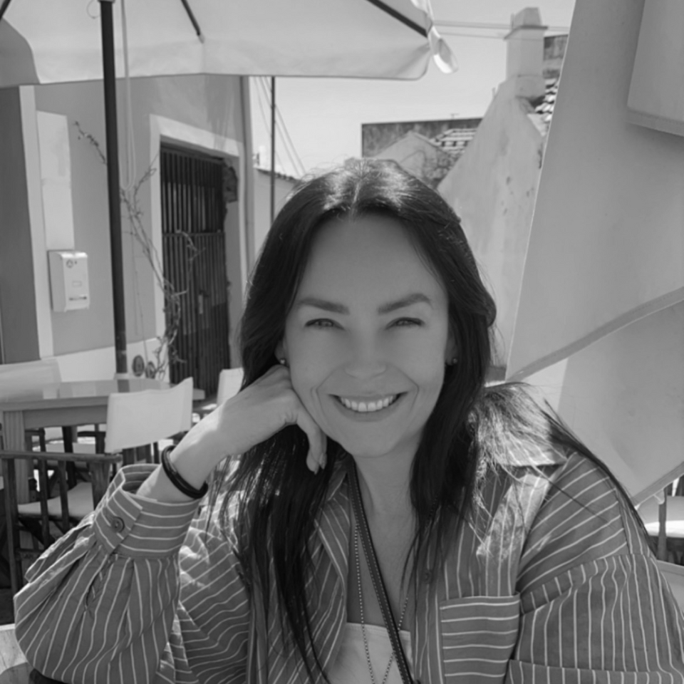 A woman in a striped shirt is smiling in a black and white photo