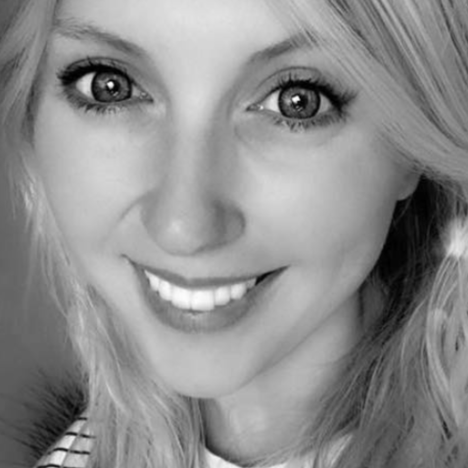 A close up of a woman 's face smiling in a black and white photo.