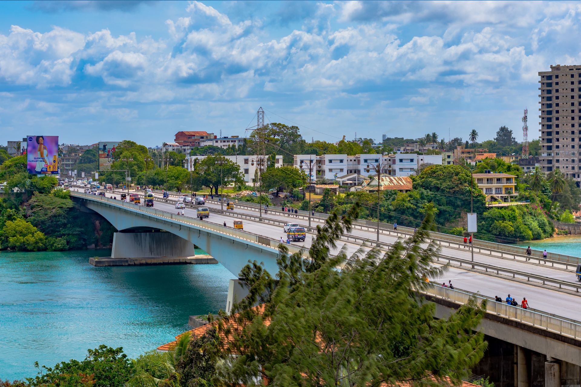 There is a bridge over a body of water in the middle of a city.