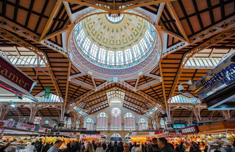 A large building with a dome on top of it filled with people.