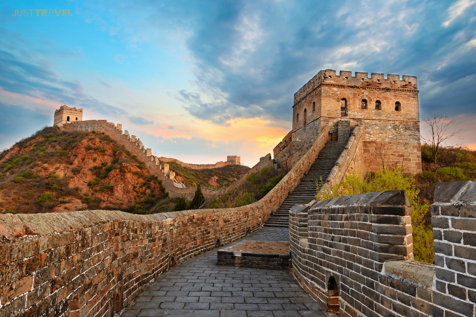 The great wall of china is a very long brick wall with stairs leading up to it.