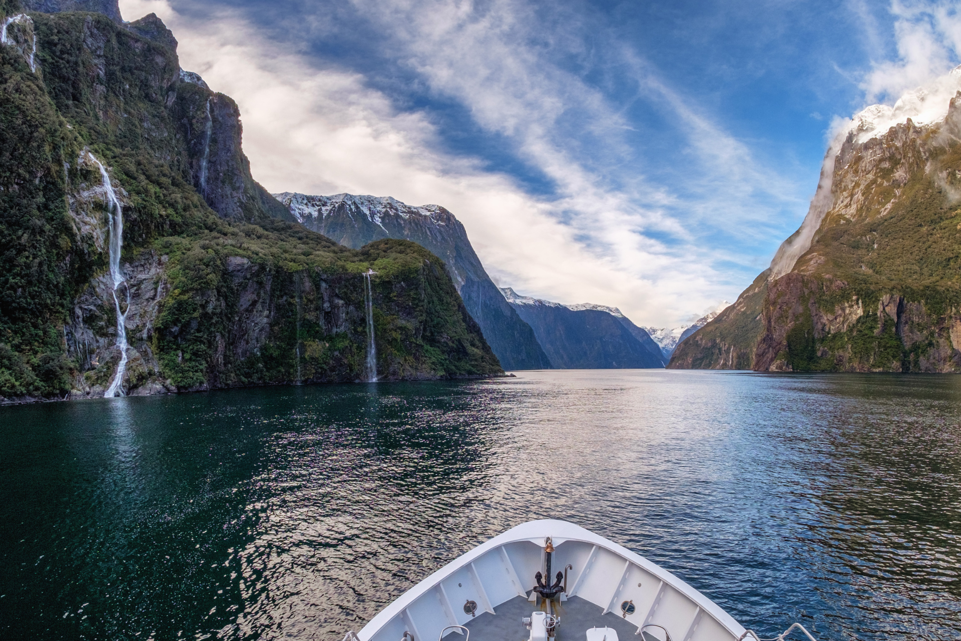 A boat is floating on a lake with mountains in the background.