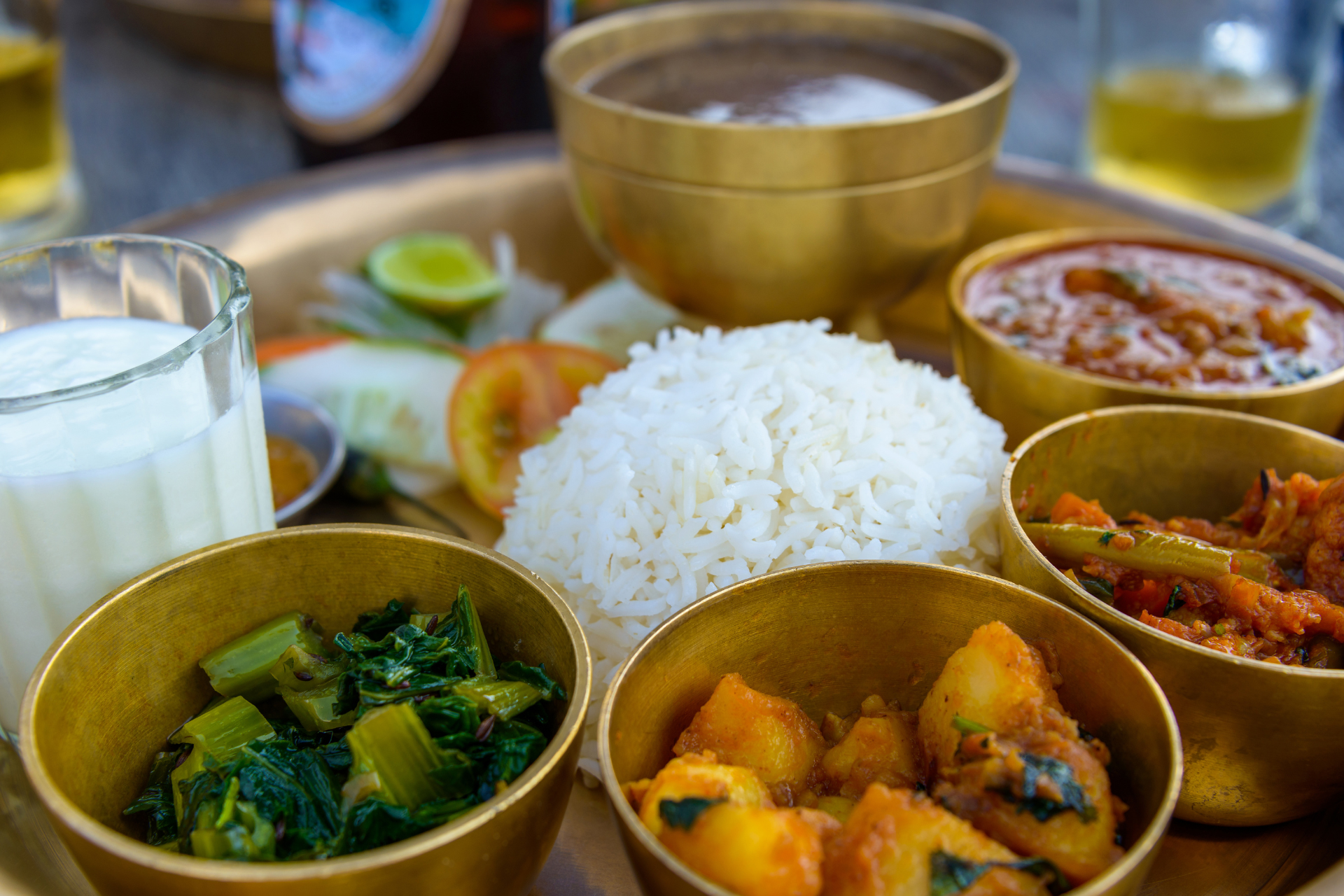 A tray of food with rice , vegetables , and a glass of milk.