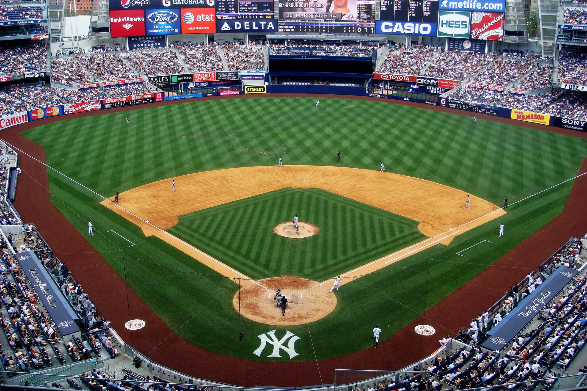 An aerial view of a baseball stadium with ny on the field