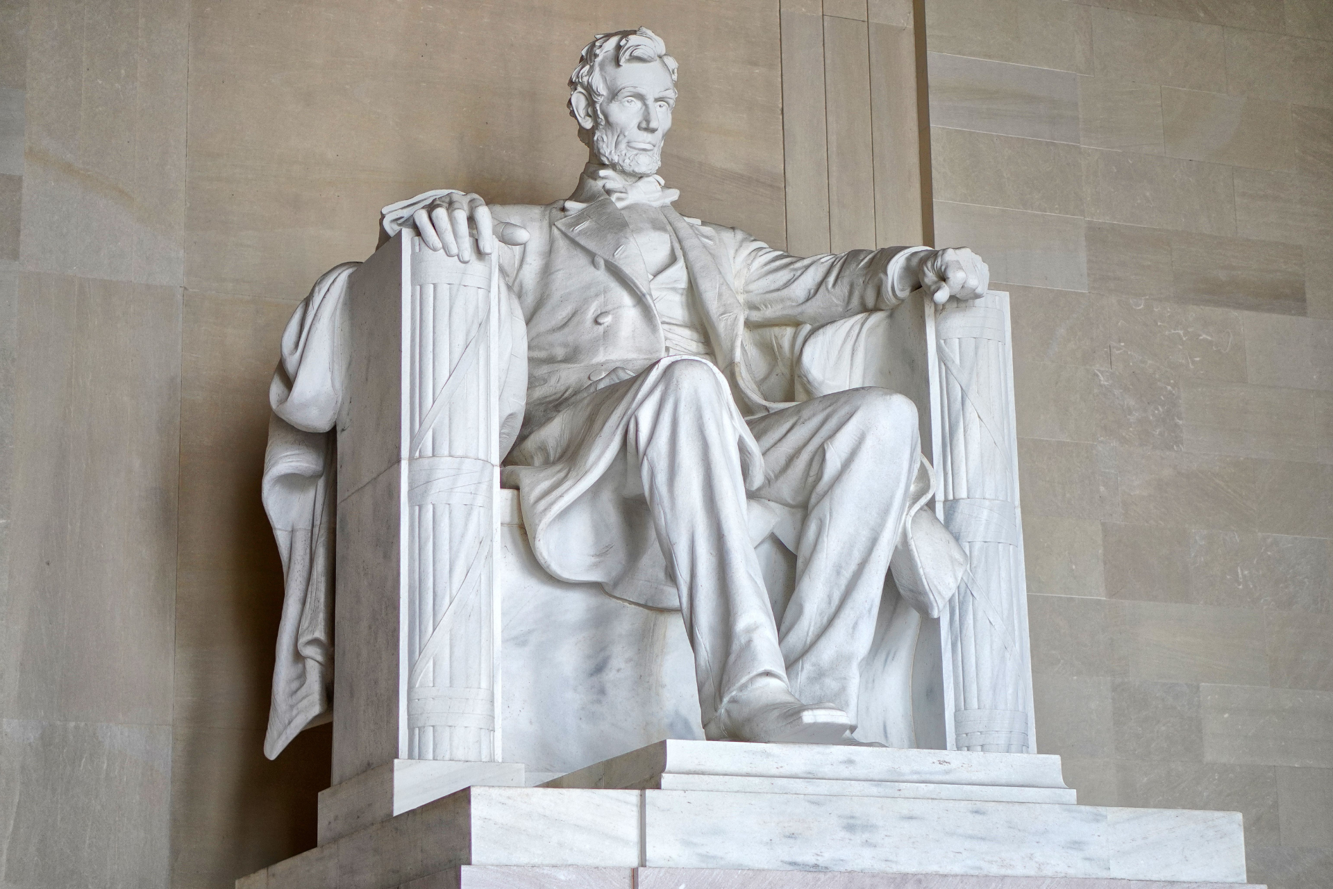 A statue of abraham lincoln is sitting in a chair.