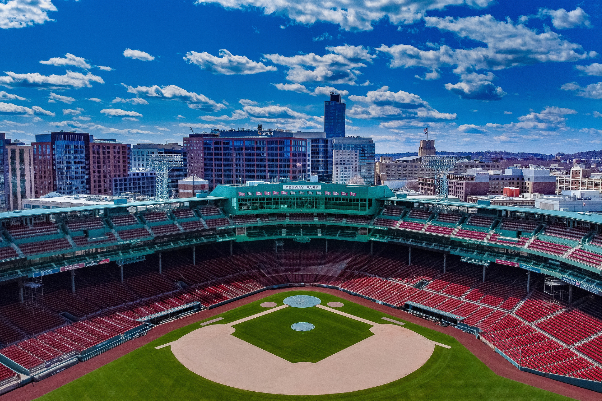 An aerial view of a baseball stadium with a city in the background.