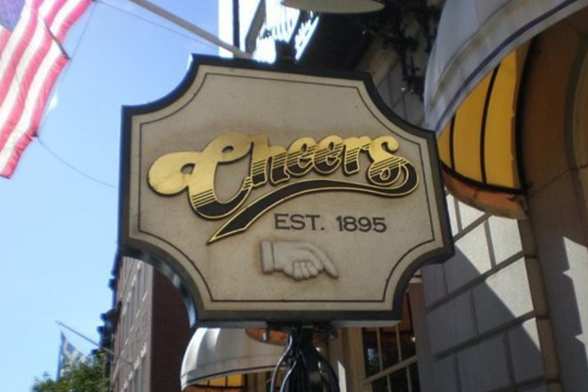 A sign for cheers est 1895 hangs from the side of a building