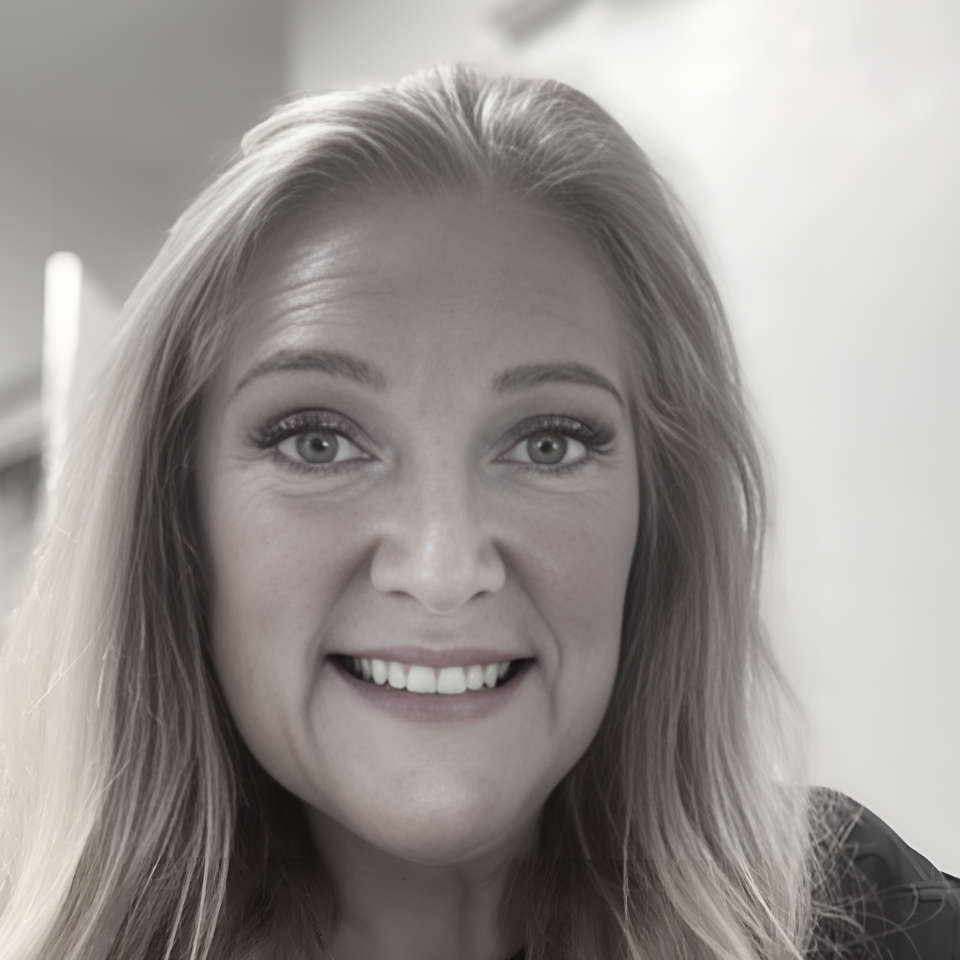 A woman with long blonde hair is smiling in a black and white photo