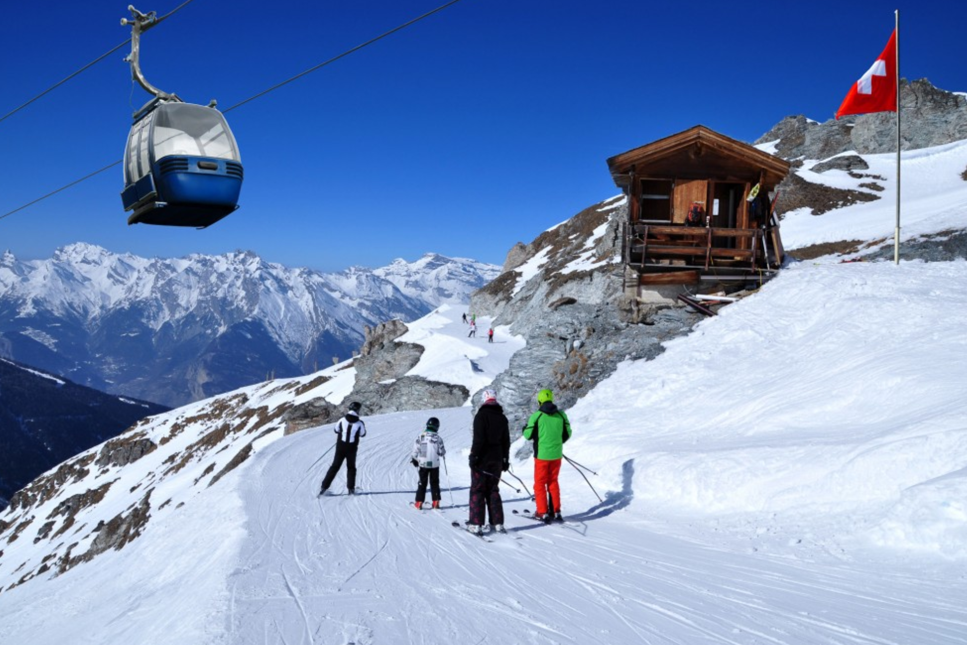 A group of people skiing down a snow covered slope with a ski lift in the background