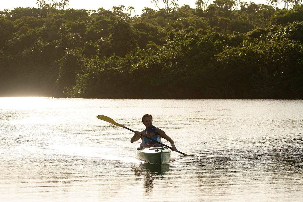 A man is paddling a kayak on a lake